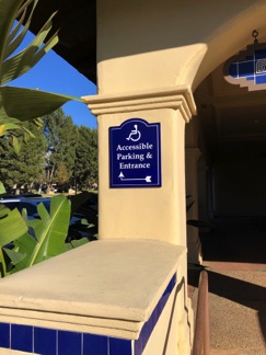 photo of a retro style accessible directional sign mounted on a column 